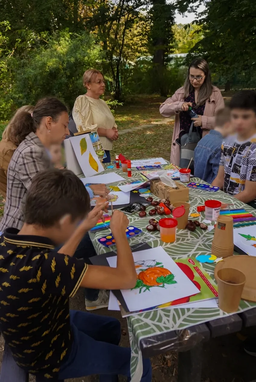 Copii pictând și creând la atelierul în aer liber